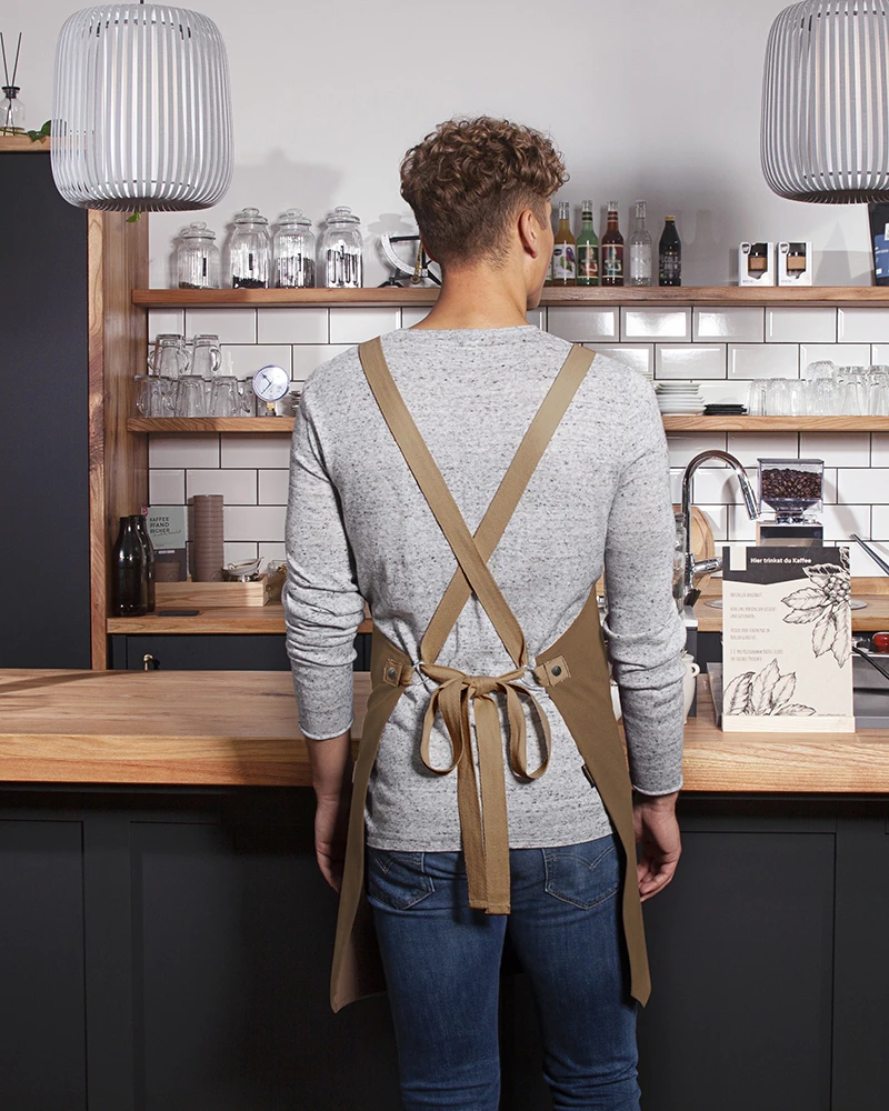 karlowsky-ls38-latzschuerze-urban-look-mit-kreuzbaendern-und-tasche-cinnamon-model-1 KARLOWSKY Latzschürze Urban-Look mit Kreuzbändern und Tasche